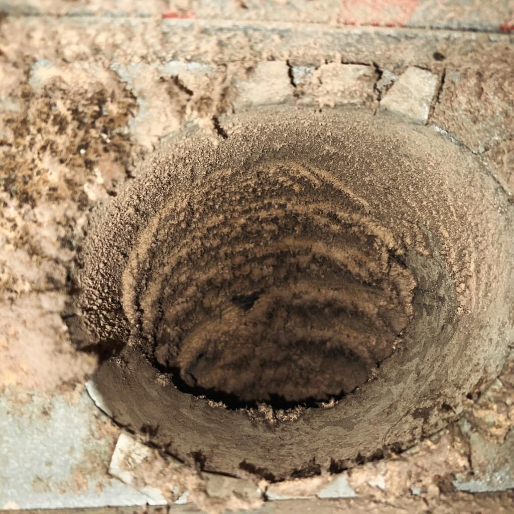 Clogged dryer vent packed with heavy lint buildup.